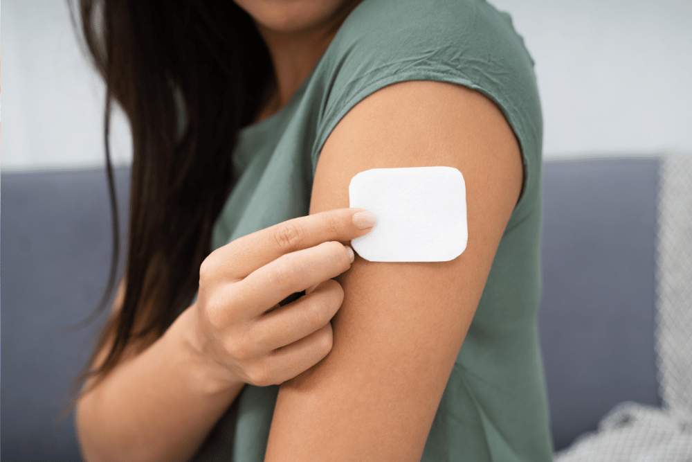 woman applying transdermal fentanyl patch - Avenues Recovery